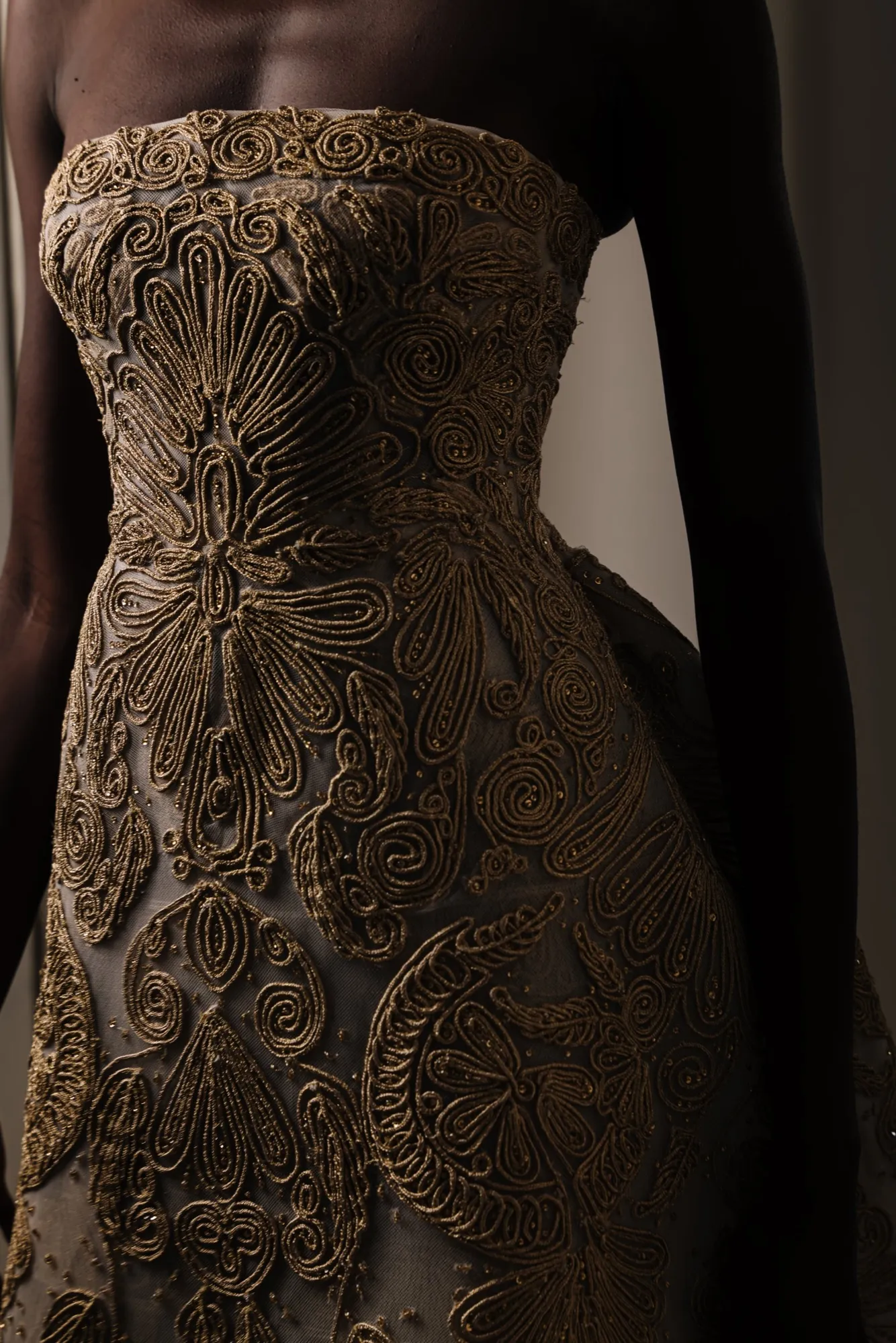 Gold embroidered gown on a dark background