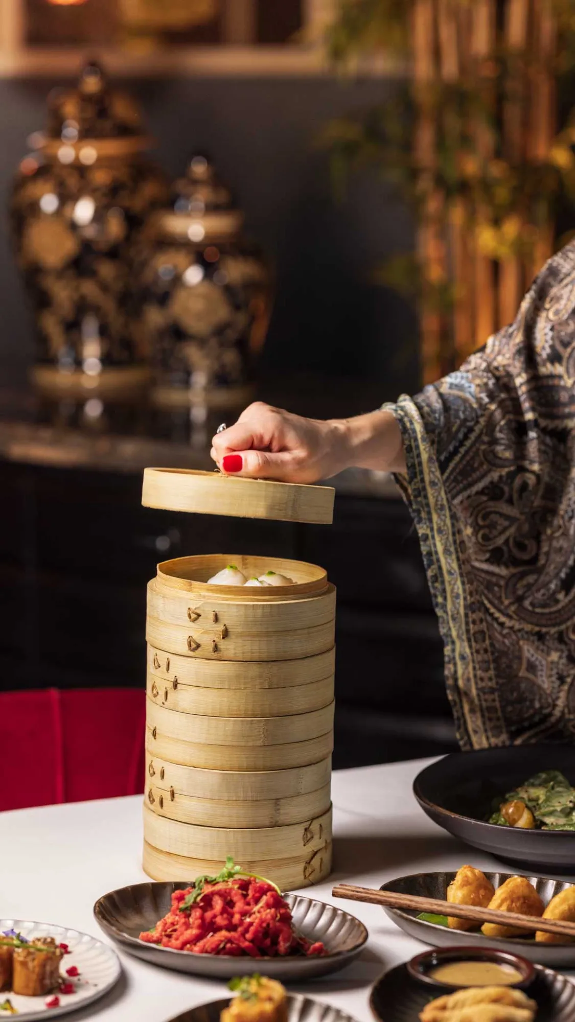 Bamboo dim sum steamers lifted at the table