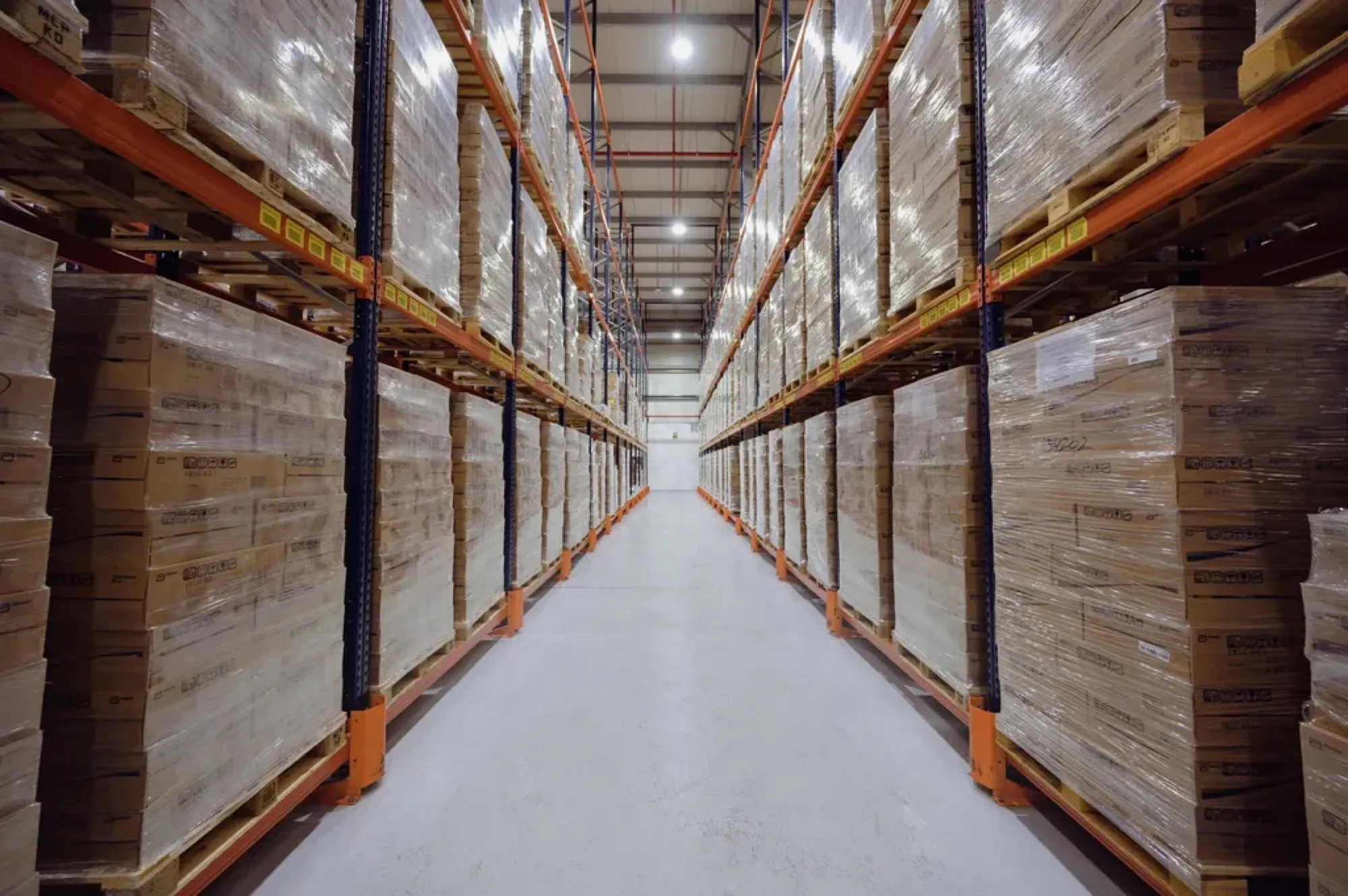 Long warehouse aisle racked to the ceiling