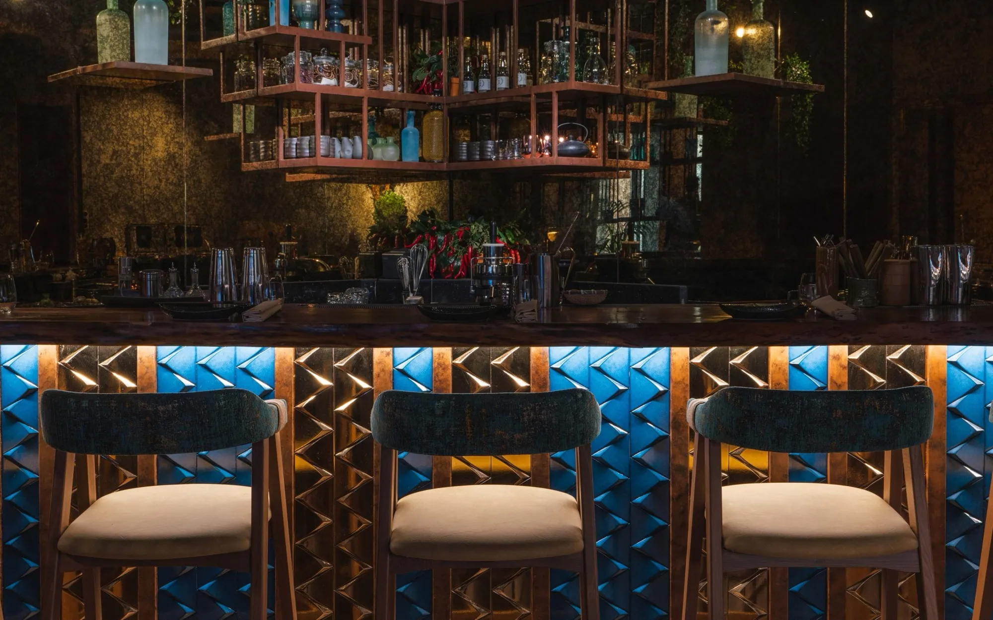 Kuuru's bar, bottles lit above a blue tiled counter