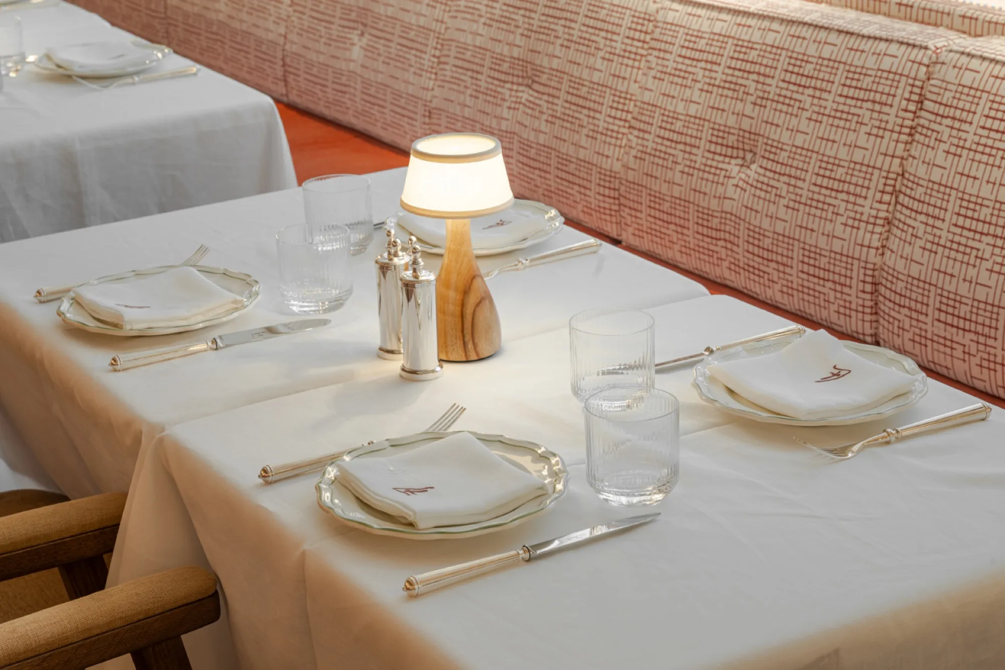 Table laid with white linen and a small lamp
