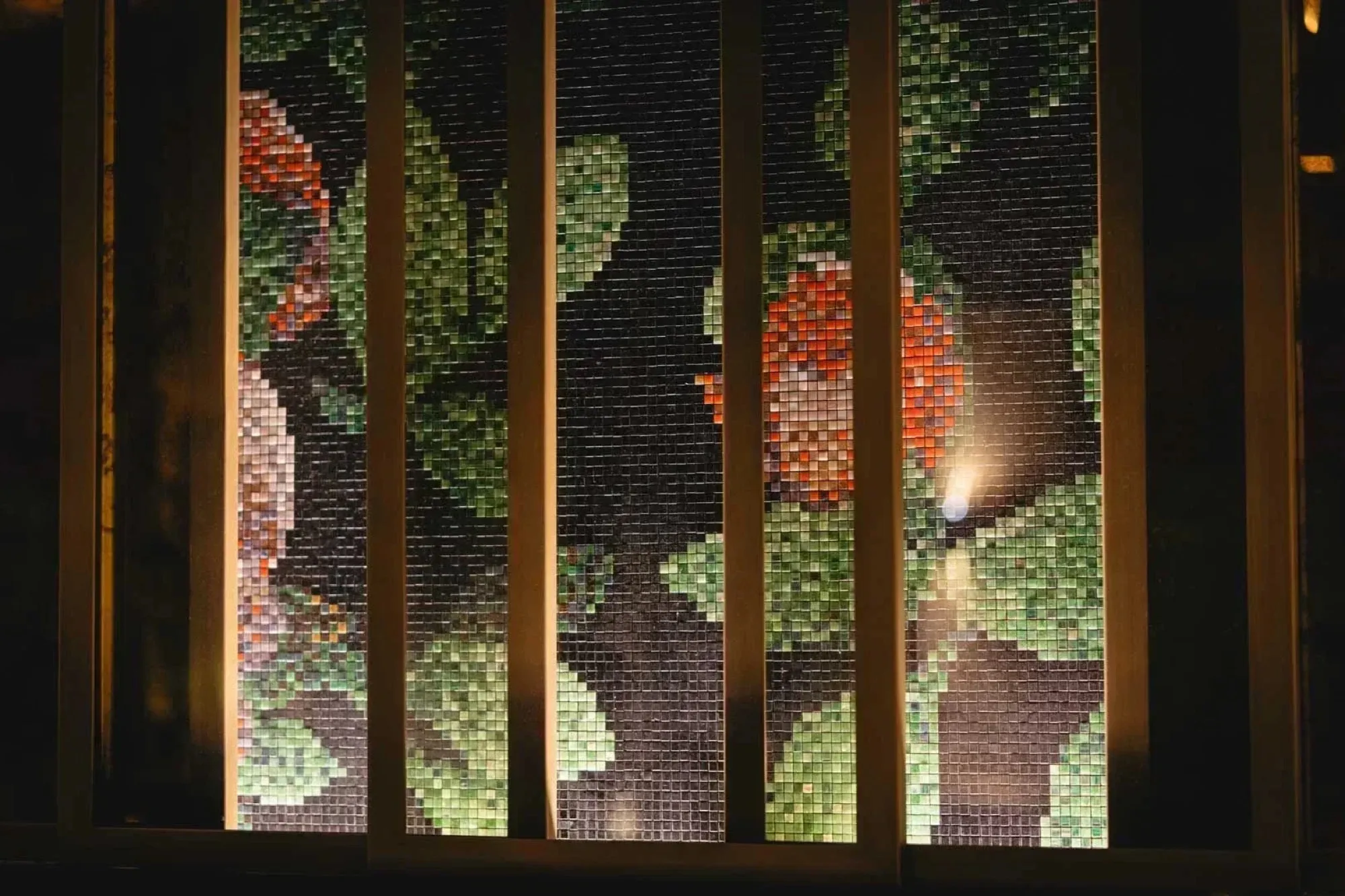 Mosaic art wall behind wooden screens