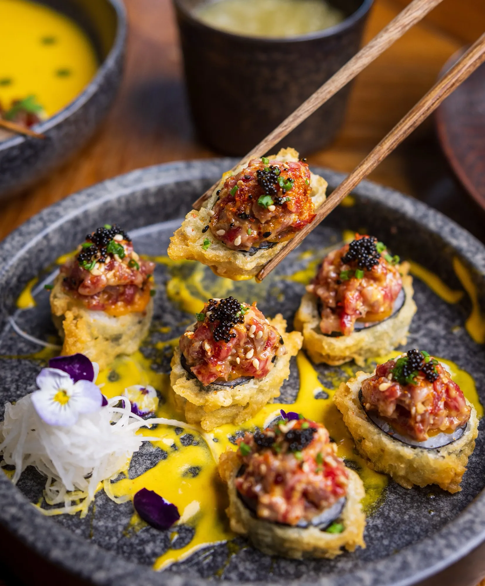 Canapés topped with caviar and edible flowers