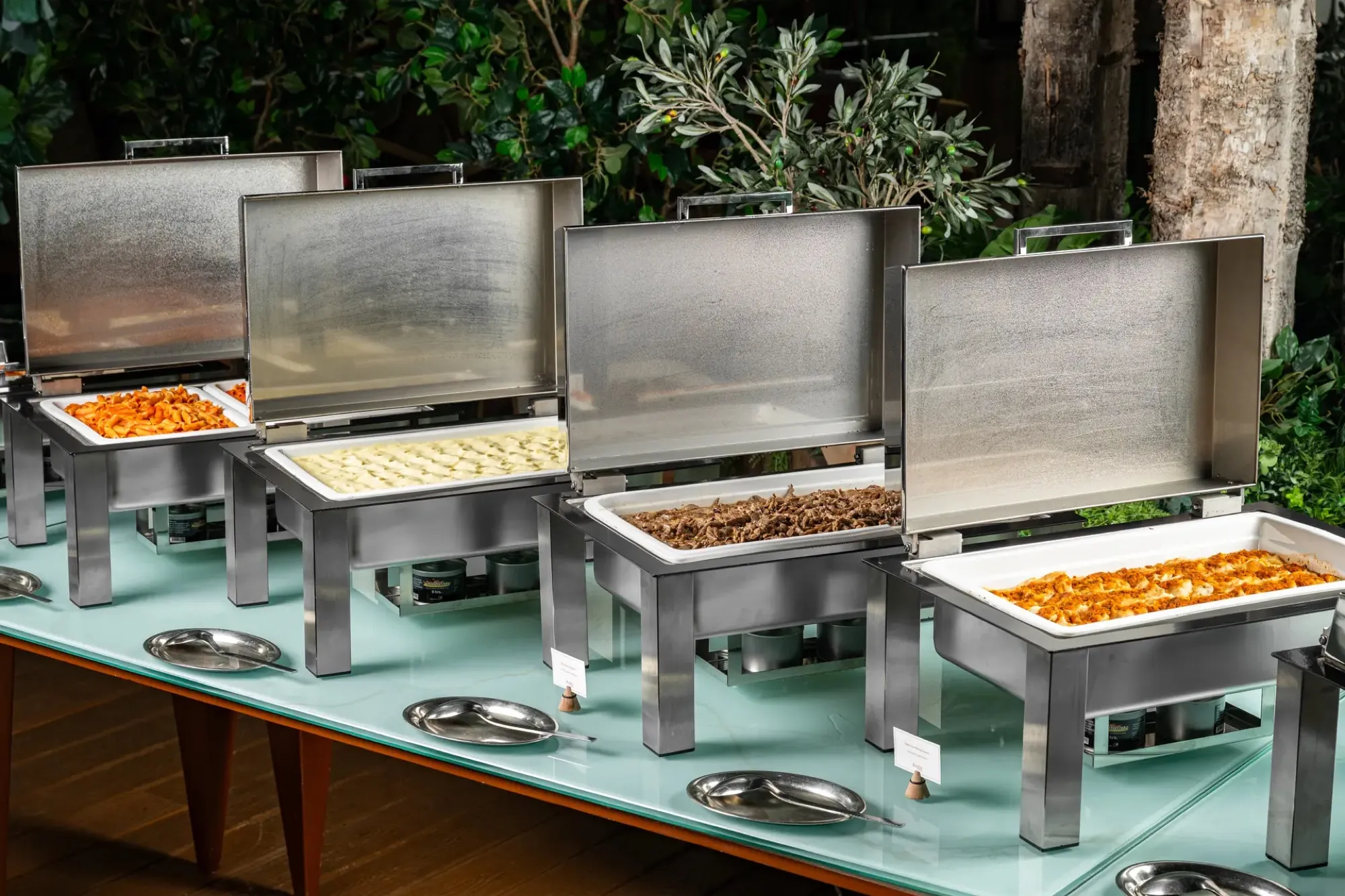 Chafing dishes on a mint-topped catering table